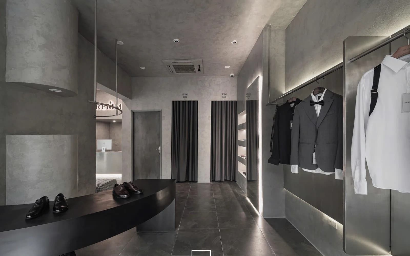 Khu thử đồ với suit và tuxedo trưng bày cùng rèm phòng thử tại showroom REMMY